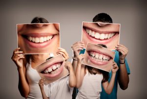 A family holds up photos of their smiles maintained by expert general dentistry.