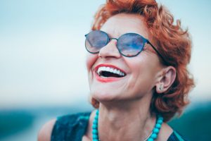 Elderly woman laughing to show off her cosmetic dentistry.