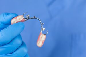 dentist holding a partial denture appliance
