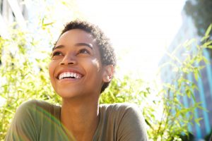 A woman is smiling about the results of her cosmetic dentistry procedure.